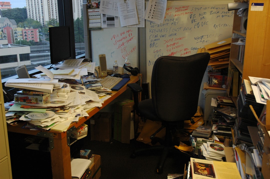 A cluttered desk with a sticky note showing the 1-3-5 rule prioritization framework next to a crossed-out Eisenhower Matrix diagram.