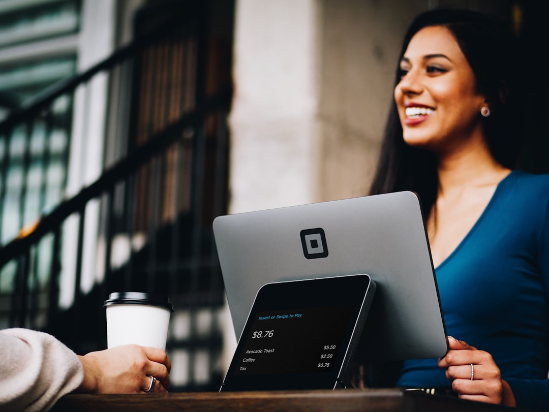 A freelancer reviewing a paid test project contract on a laptop with a coffee cup nearby